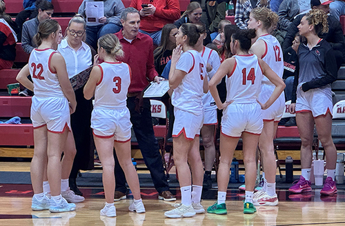 Northeast women's basketball coach encouraging players in team huddle