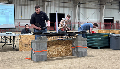 students building and testing popsicle bridges