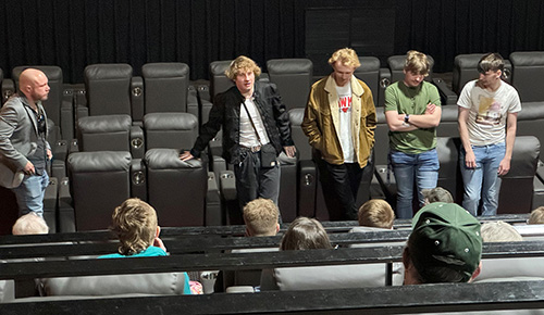 media arts students discussing film after premiere in theater