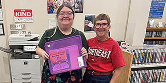 instructor and library employee hold a reading kit