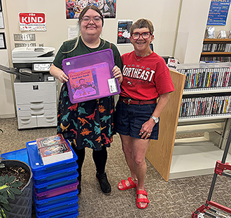 instructor and library employee hold a reading kit