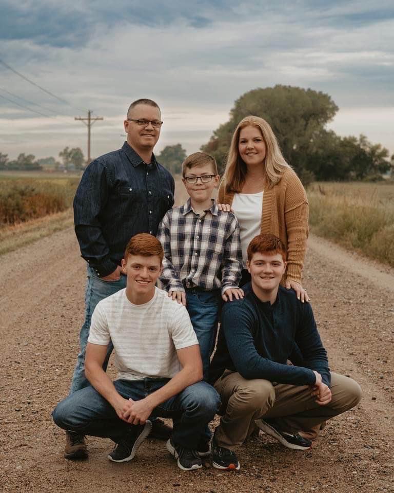 5 person family group photo on a dirt road