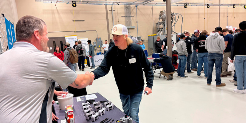 Prospective employer shakes hand with student