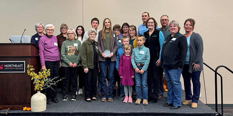 Kristen Sindelar holding award with family