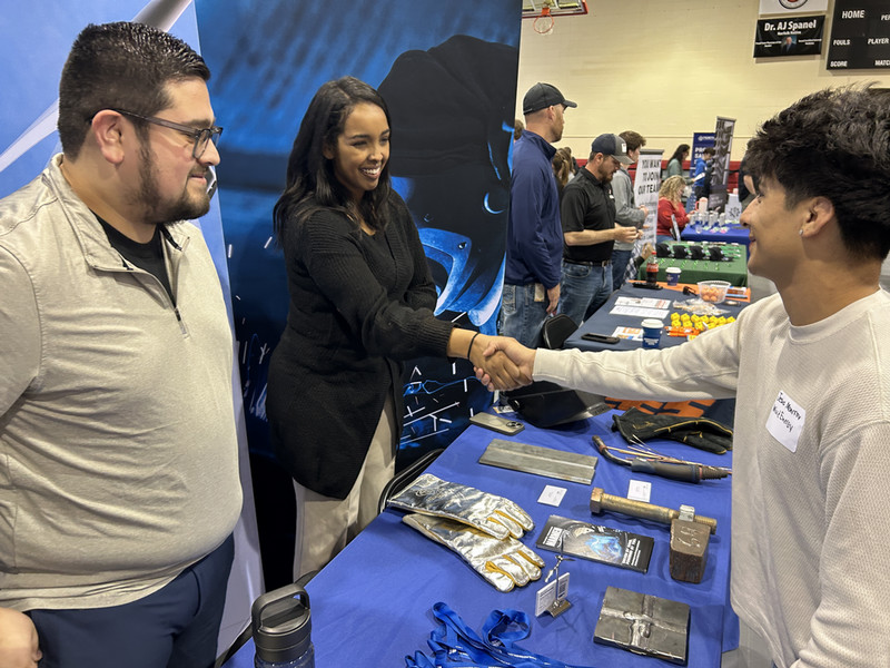 Jesus Montalvo visits with representatives from Agri City Insurance during a Career Fair at Northeast Community College, learning more about career opportunities and making professional connections.