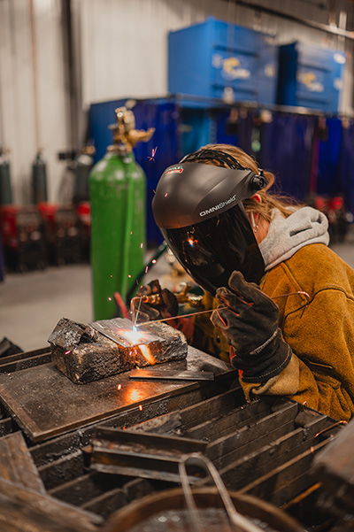 student wearing welding mask while welding