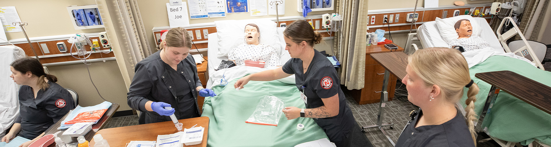 Students working with manikin in nursing lab