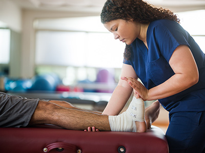 physical therapist stretching patient's foot