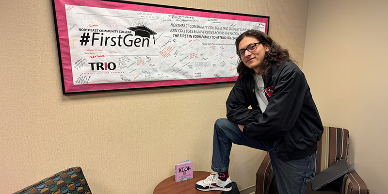 Jonathan Castro in front of first gen trio banner