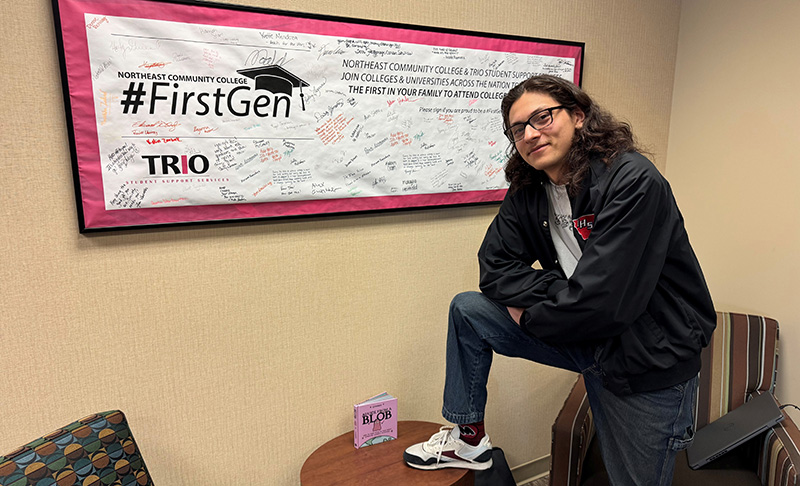 Jonathan Castro in front of first gen trio banner
